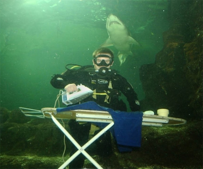 man ironing pants under water