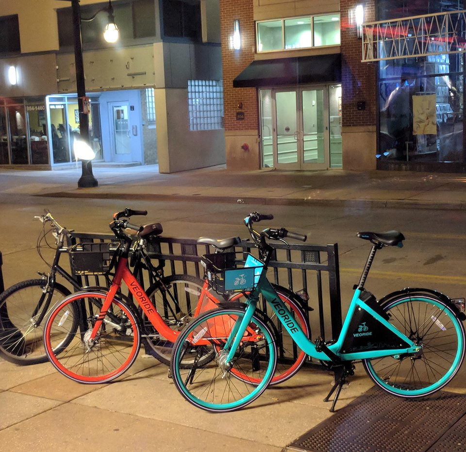 red and teal veobikes on sidewalk