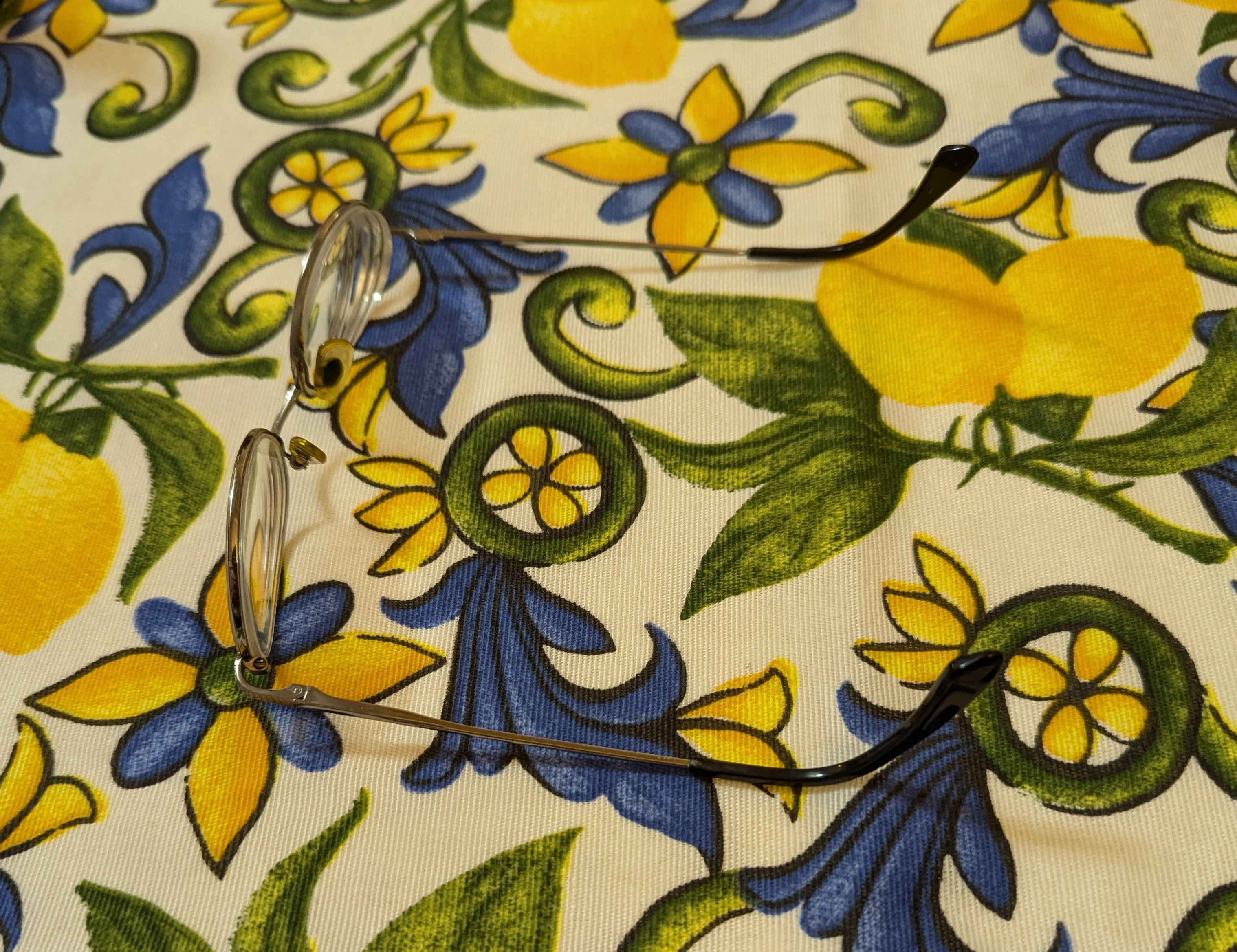 a pair of glasses ona patterned tablecloth